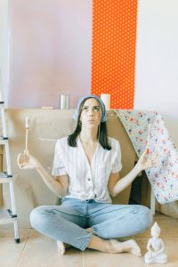 personne assise avec un pinceau dans les mains et levant les yeux au ciel