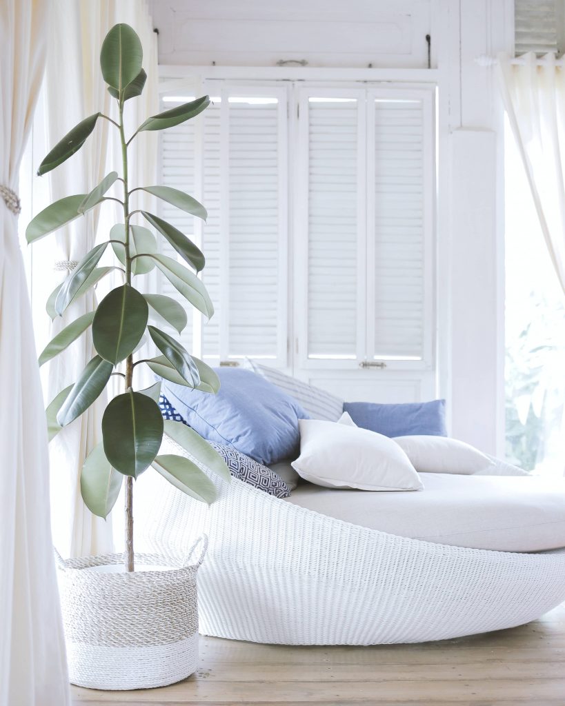 fauteuil de détente blanc avec coussins bleu ciel dans une ambiance douce et blanche