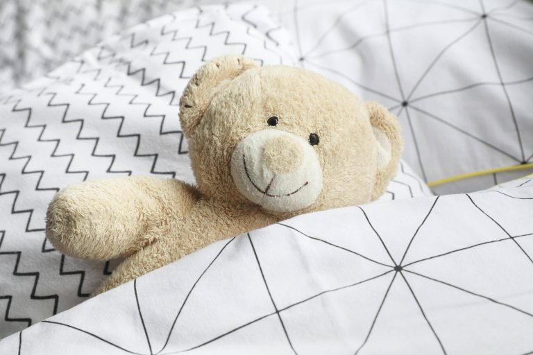 ours en peluche dans un lit d'enfant