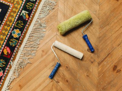 rouleaux à peinture posés sur un parquet en bois