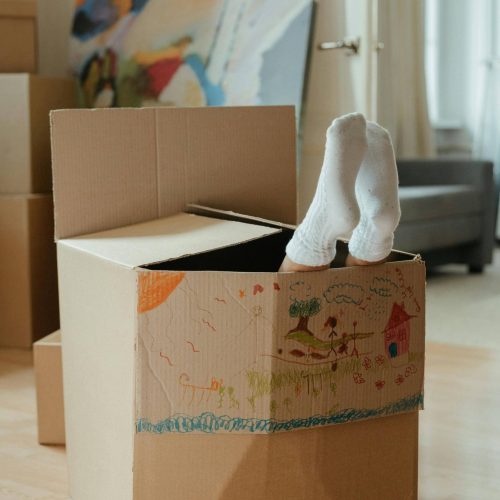 carton d'emménagement avec des pieds qui dépassent du carton